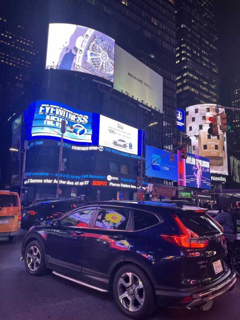 A picture of buildings and cars in New York in Times Square